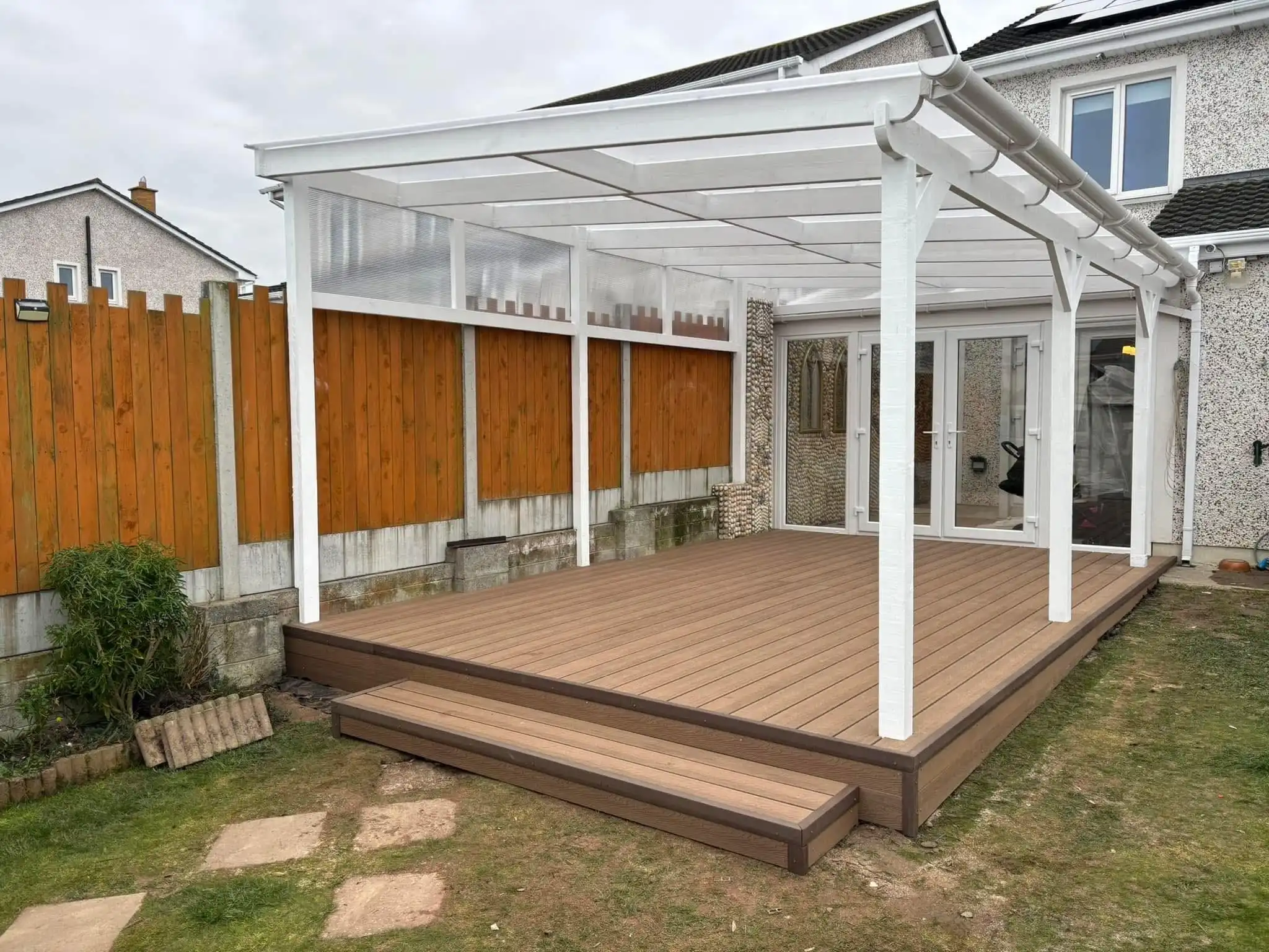 Stunning custom-built white pergola with a clear roof and composite decking by Timothy Pergola, creating a beautiful sheltered outdoor living space for an Irish garden. Specializing in high-quality, durable pergolas tailored for all seasons, Timothy Pergola enhances outdoor living across Meath, Dublin, and Ireland.