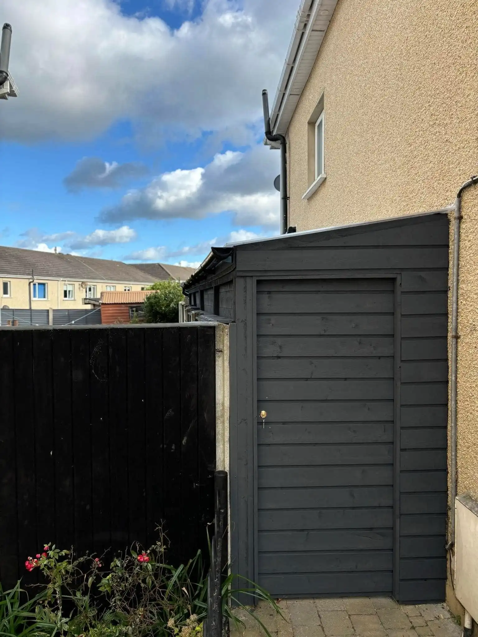 Completed dark grey lean-to shed by Timothy Pergola, demonstrating efficient use of a narrow side passage for functional storage at an Irish home. Offering over 20 years of experience, Timothy Pergola specializes in custom-built lean-to sheds, pergolas, and outdoor structures across Meath, Dublin, and Ireland